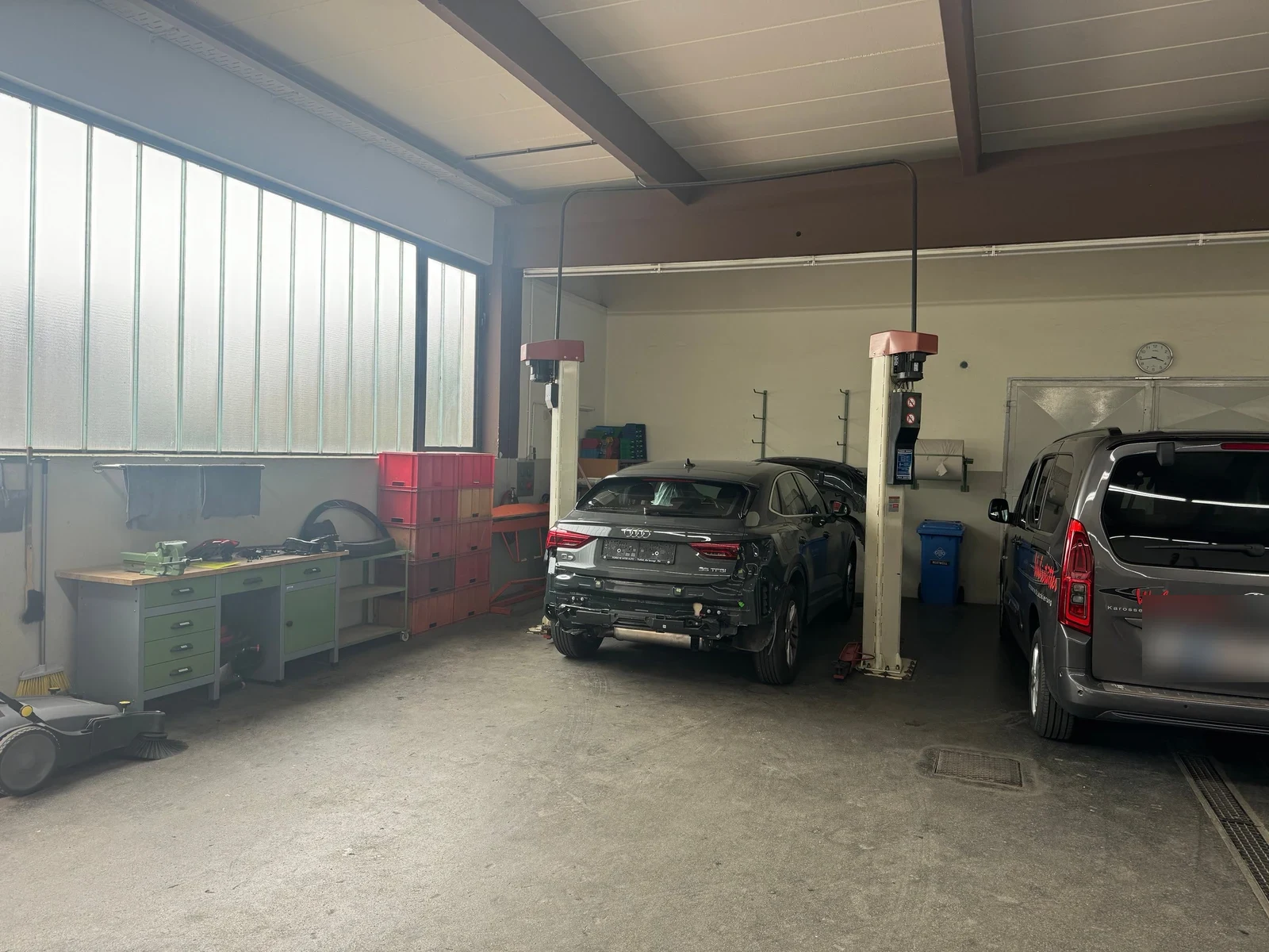 Werkstatthalle mit Hebebühne und Werkbänken